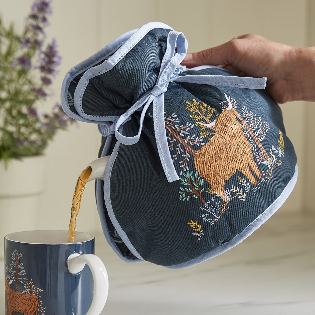 Tee-Muff von Ulster Weavers beim Tee eingießen | Connie the Highland-Cow